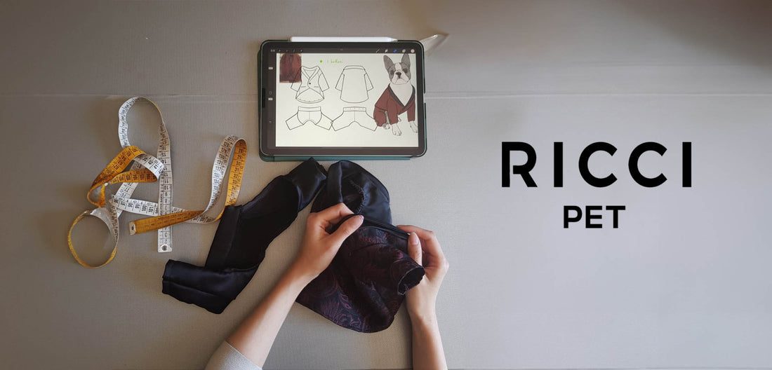 two hands working a tailoring fabric for dogs and cats. in the photo there is a tape measure and an iPad with the drawing of elegant clothes for dogs