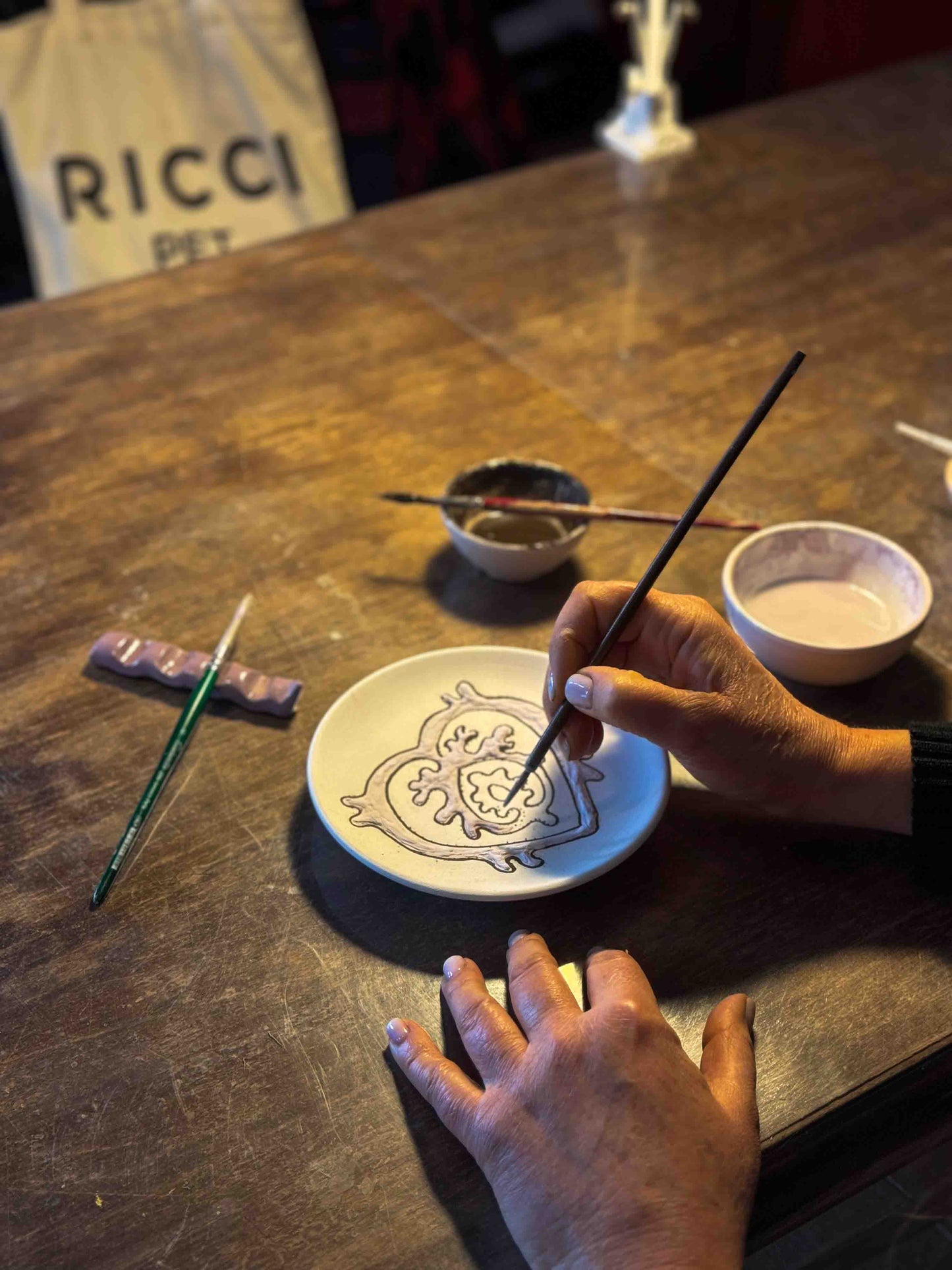 Discover the craftsmanship behind our handmade ceramic dog bowls. This photo showcases the meticulous hand-painting process, where skilled artisans apply the exclusive zaffera decoration, creating raised cobalt blue patterns. Each bowl is uniquely crafted with passion and precision, making it a beautiful and functional accessory for your pet.
