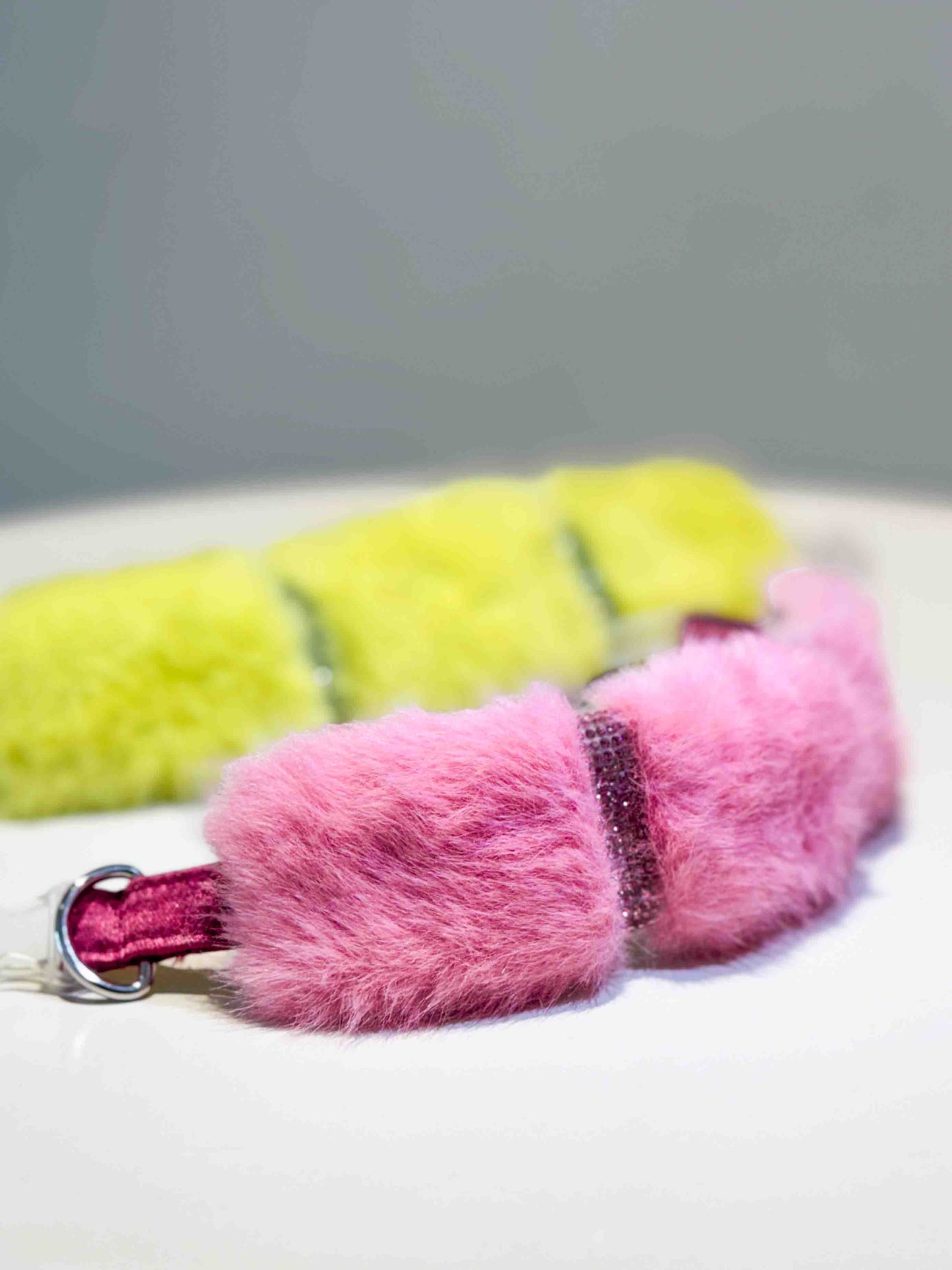 A luxurious dog collar featuring sections of soft pink and vibrant yellow fur with sparkling rhinestone accents, showcasing a colorful and elegant accessory for pets.