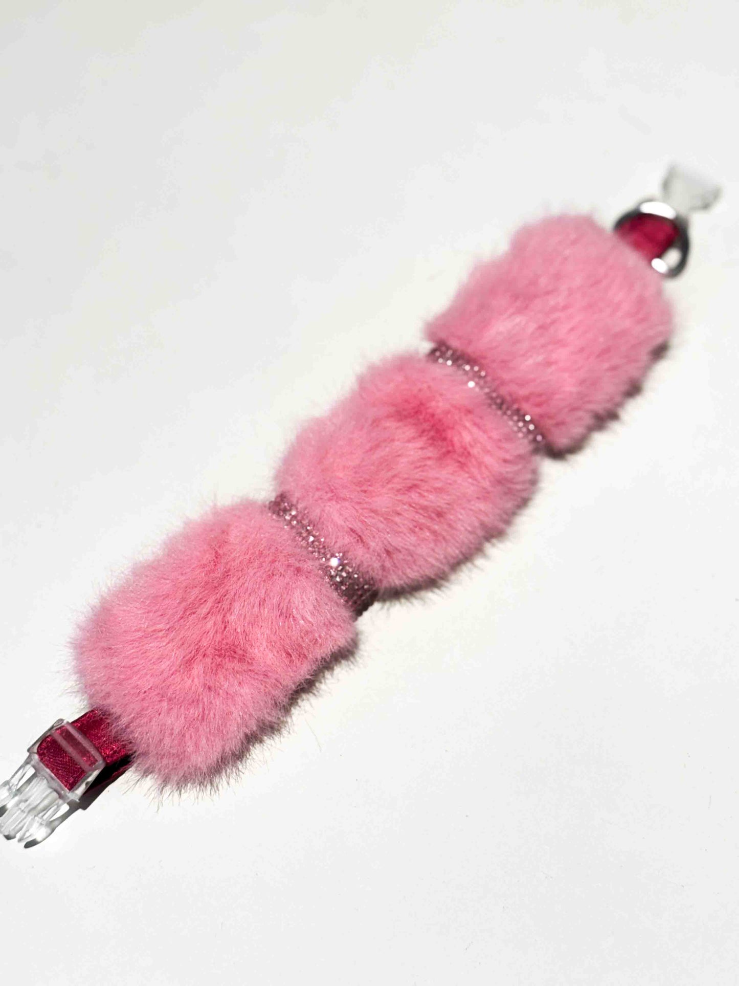 A luxurious dog collar in soft pink fur with sparkling rhinestone accents, showcasing a colorful and elegant accessory for pets.