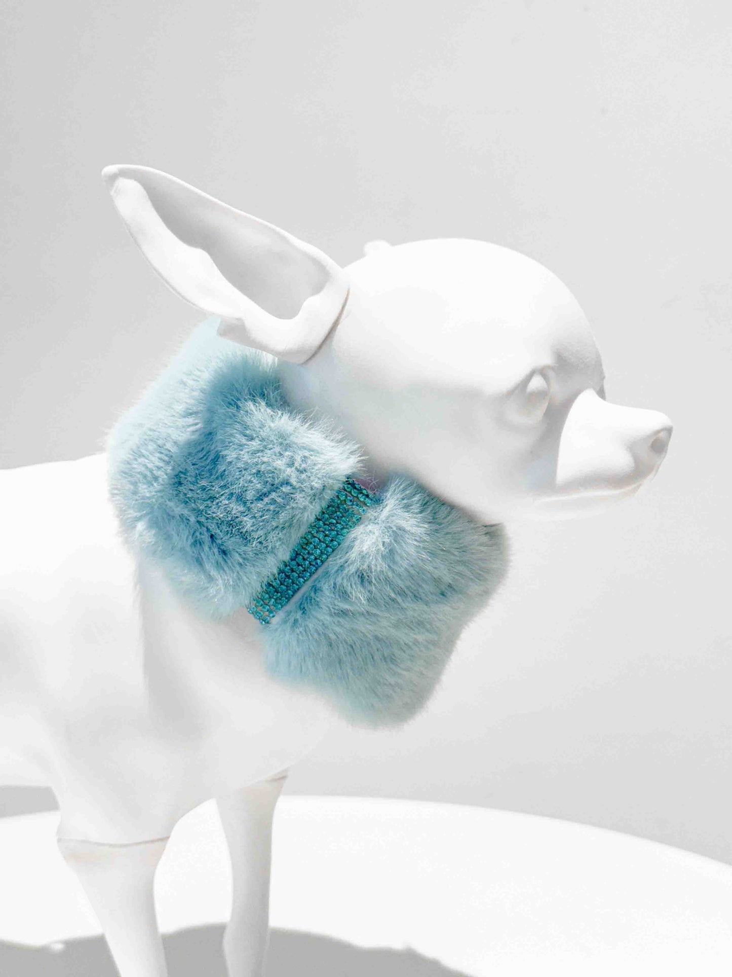 A luxurious light blue fur dog collar adorned with sparkling rhinestones, displayed on a white dog mannequin, showcasing a stylish and elegant accessory for pets.